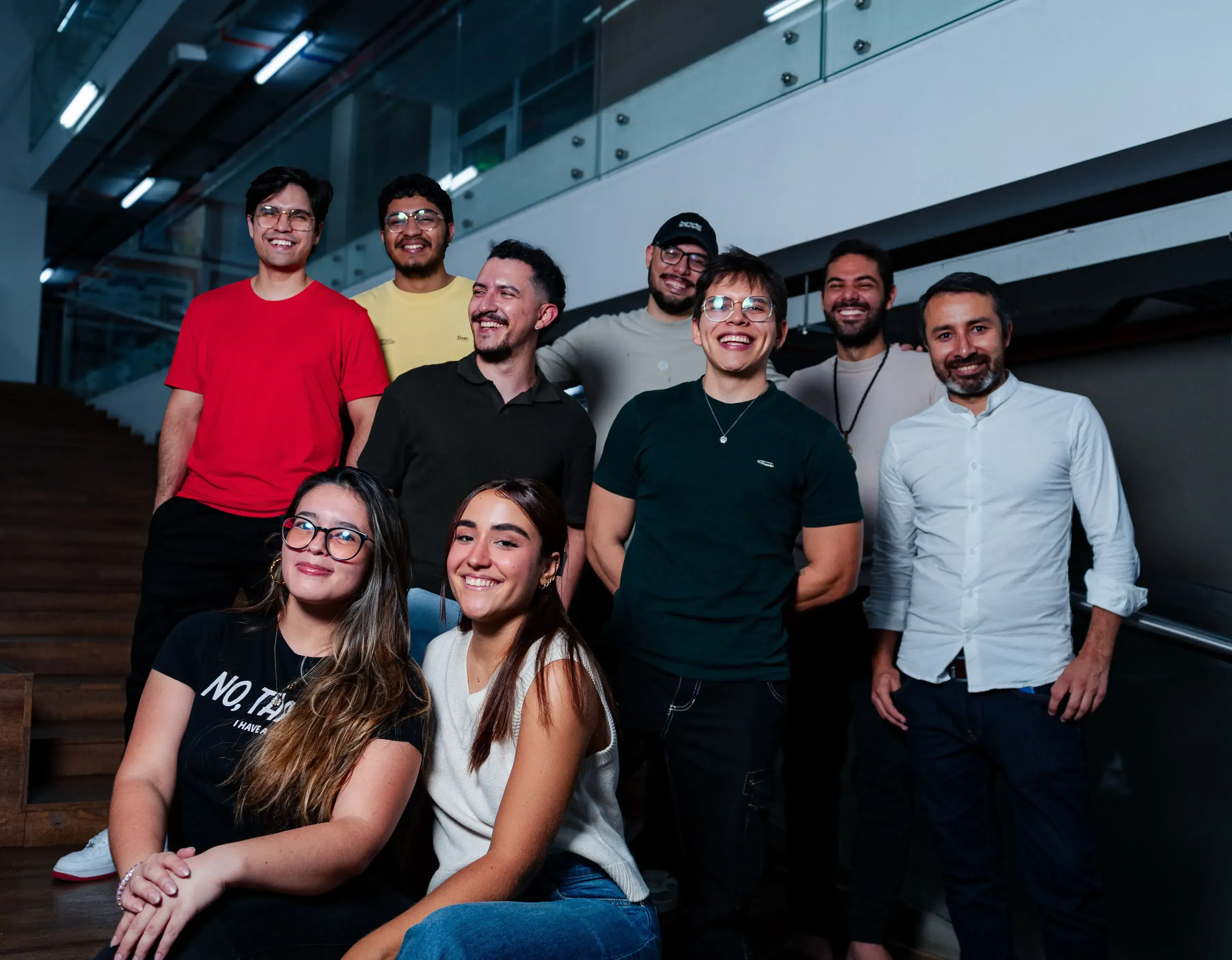 Un grupo de tres personas, sentadas en una mesa mientras trabajan y comparten ideas.